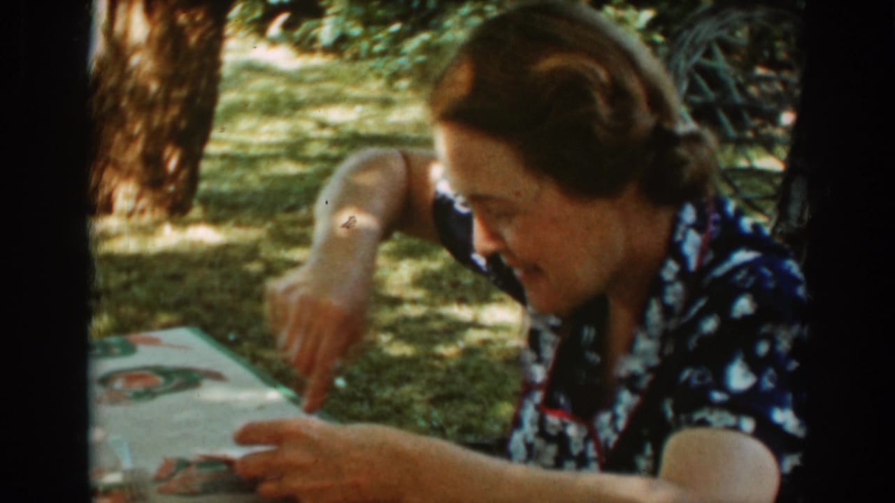 Woman in a floral dress eating with a spoon at an outdoor picnic table.