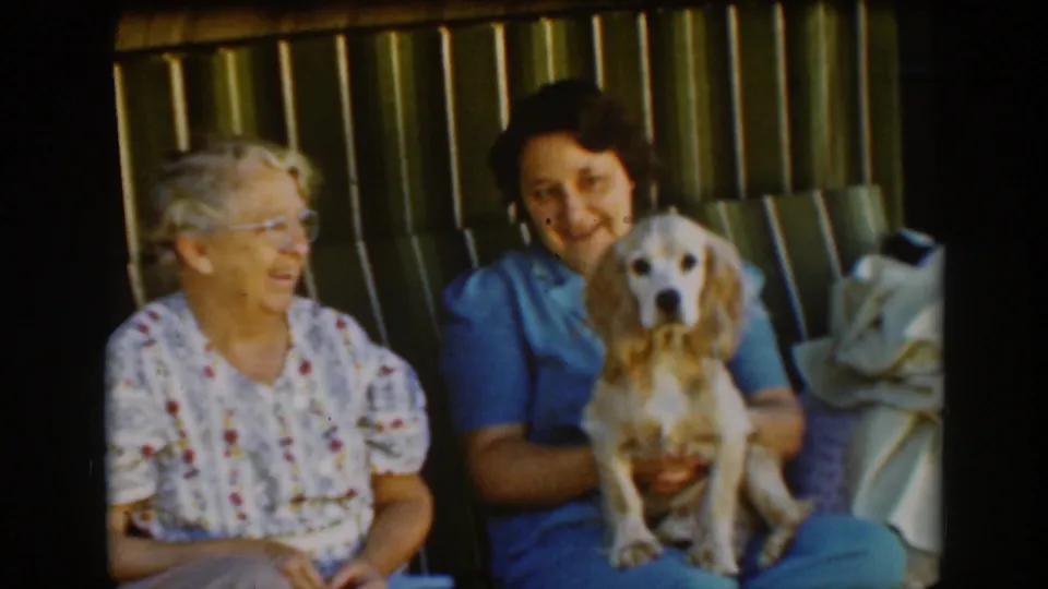 In the final 1939 Auburn frame, the seated women remain close together as the younger woman holds the small cocker spaniel facing outward.