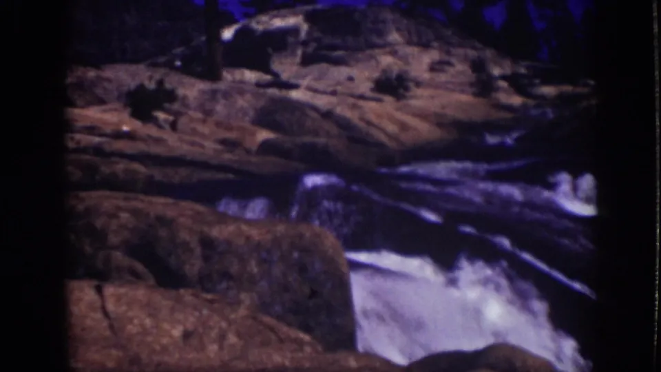 A wider 1939 Lake Tahoe home-movie view shows rocks and whitewater in a mountain stream channel.