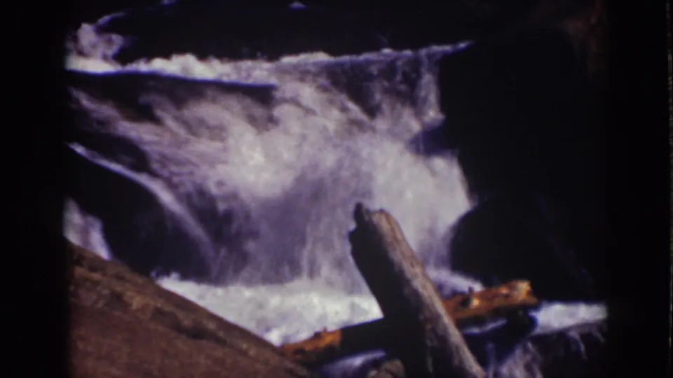 1939 Lake Tahoe frame with fast whitewater filling the center and a large log cutting across the lower foreground.