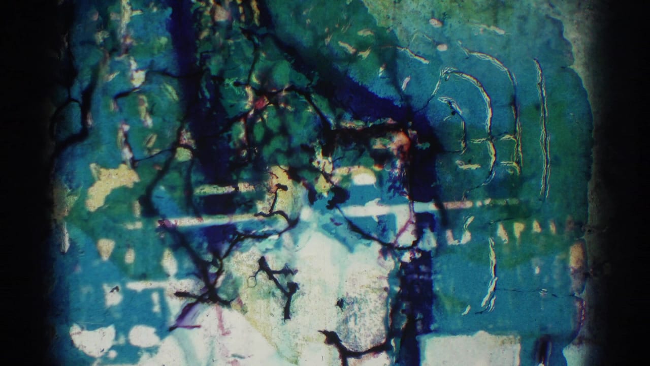 Damaged blue-green 8mm leader or overexposed film frame with scratches and dark edges.