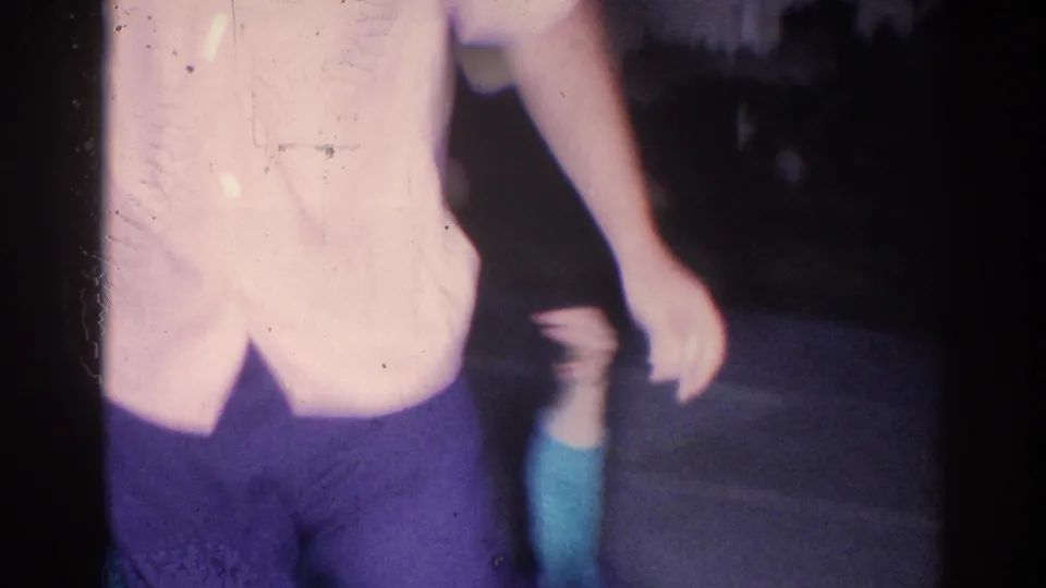 A close, handheld frame crops the man in a light shirt while the woman appears partly below during the playful movement.