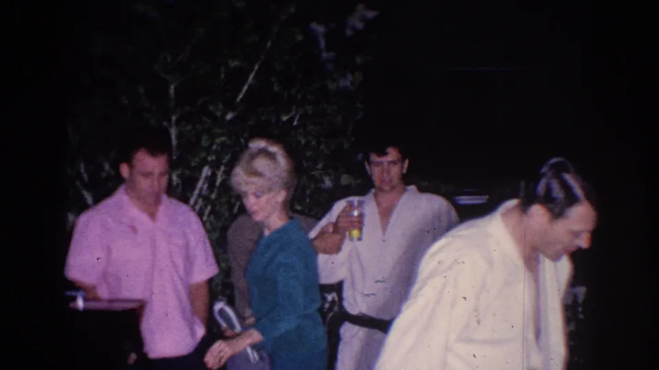 A woman in a teal dress moves through a 1966 El Monte backyard party scene as men stand nearby with drinks.