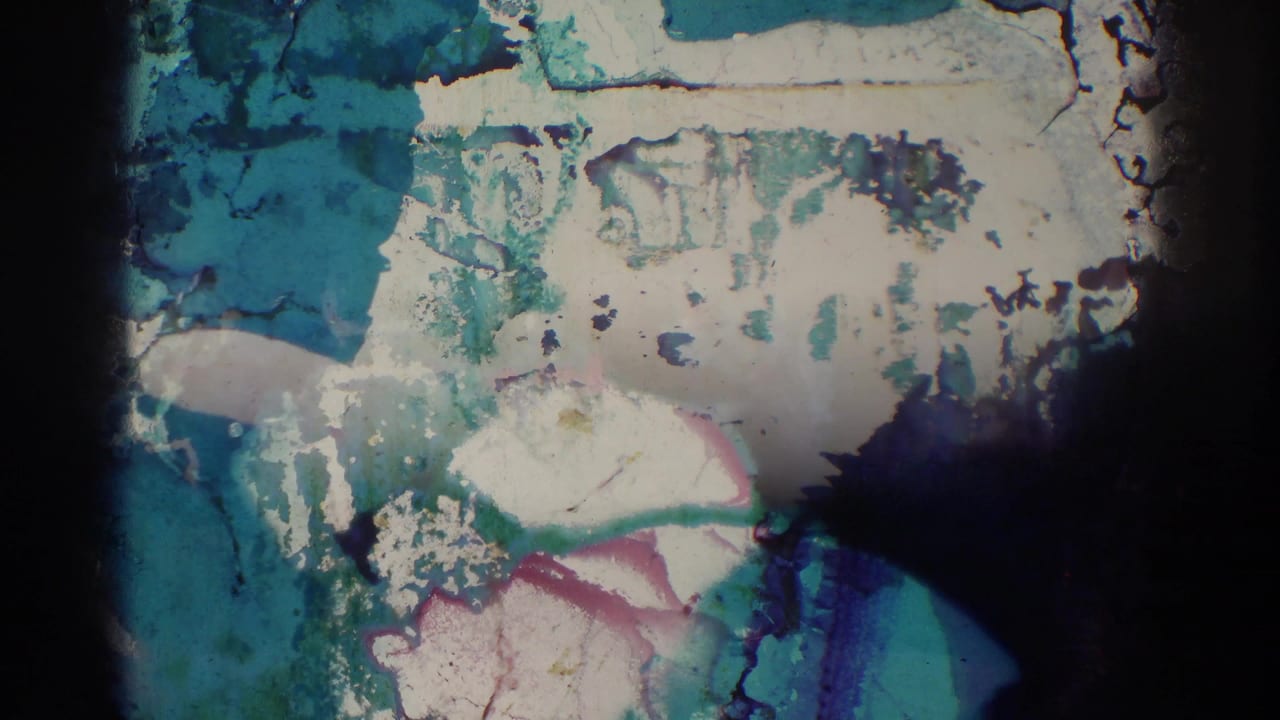 1966 El Monte 8mm frame with heavy chemical staining and partial human forms mostly obscured by film damage.