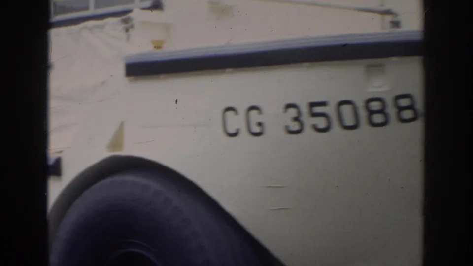 Close-up of the amphibious vehicle side with CG 35088 marking, wheel, and dark film-frame edges visible.