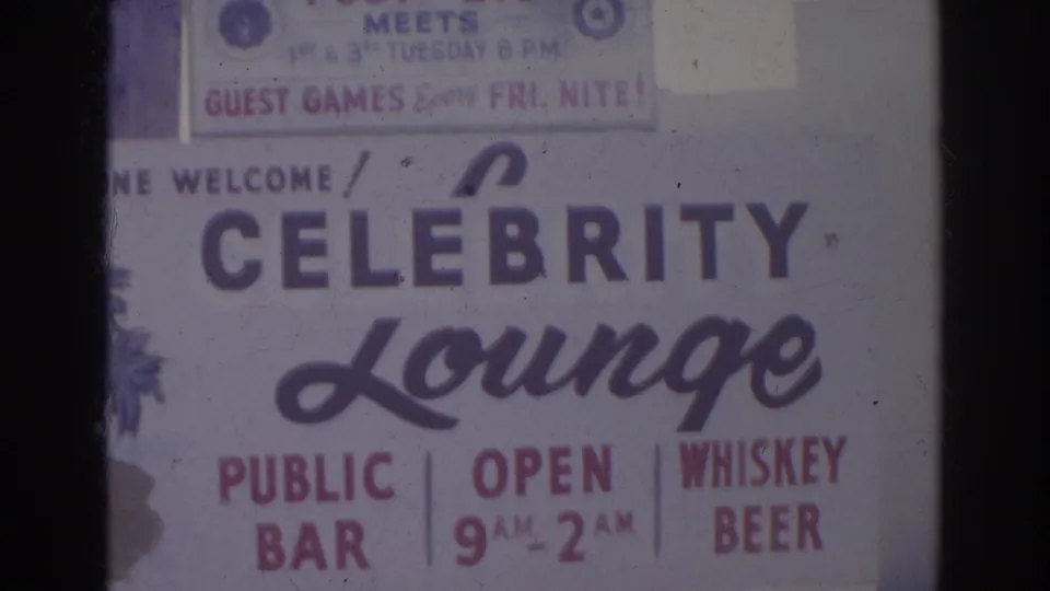 Close 8mm view of the Celebrity Lounge sign in Norfolk, with public bar text, 9 AM to 2 AM hours, and partial lodge placard above.