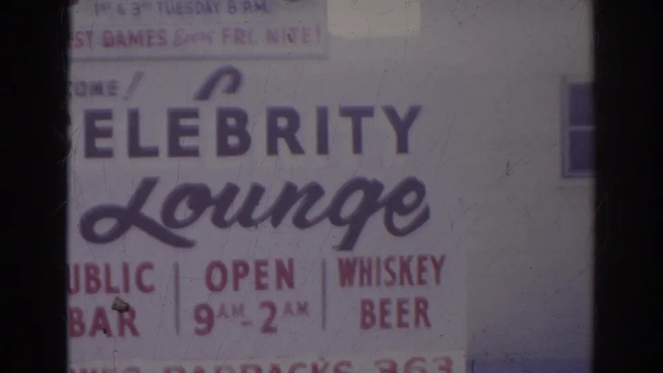 1966 Norfolk home-movie frame with the left portion of the Celebrity Lounge sign, showing lounge lettering, public bar copy, hours, and alcohol wording.