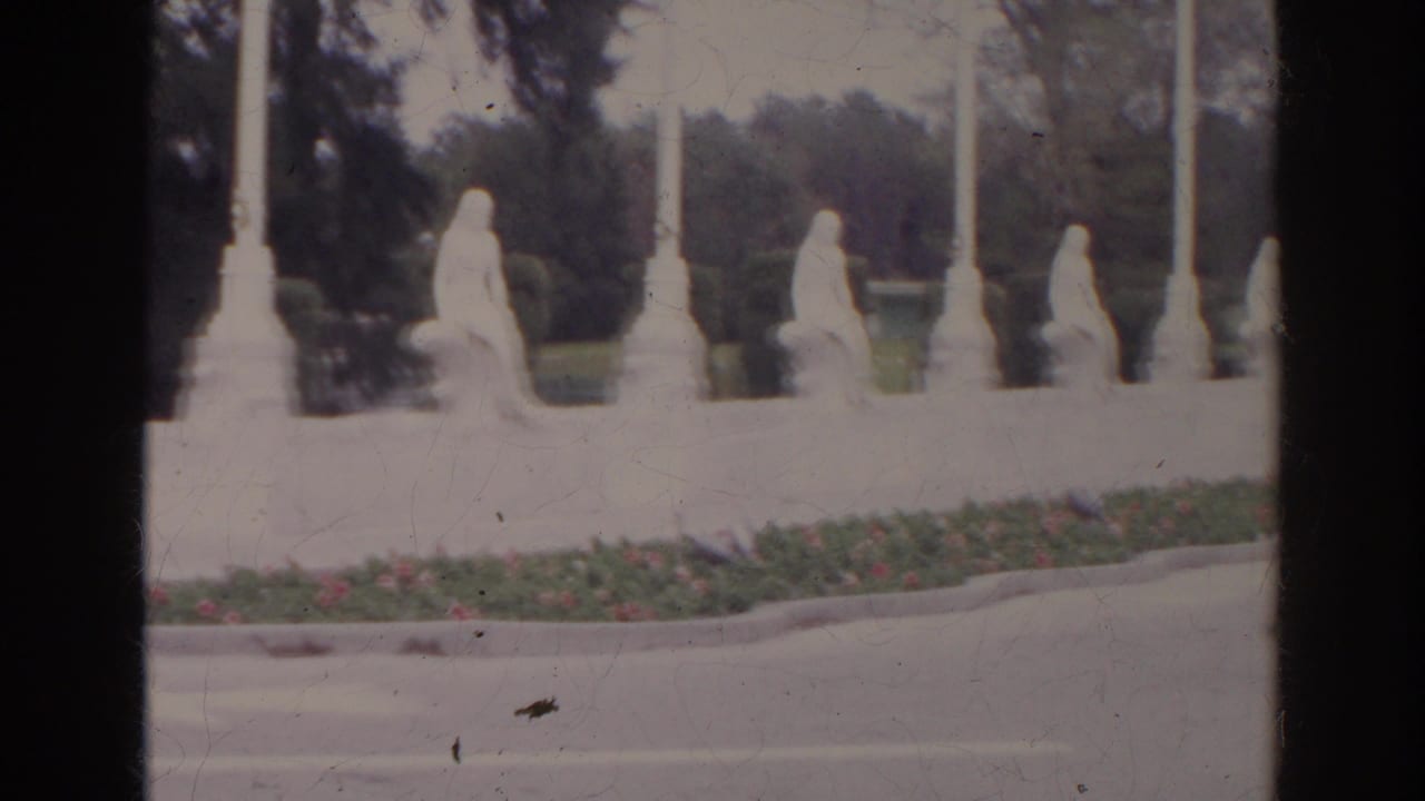 1966 8mm frame of white seated statues along a landscaped median in the documented Norfolk, Virginia clip.