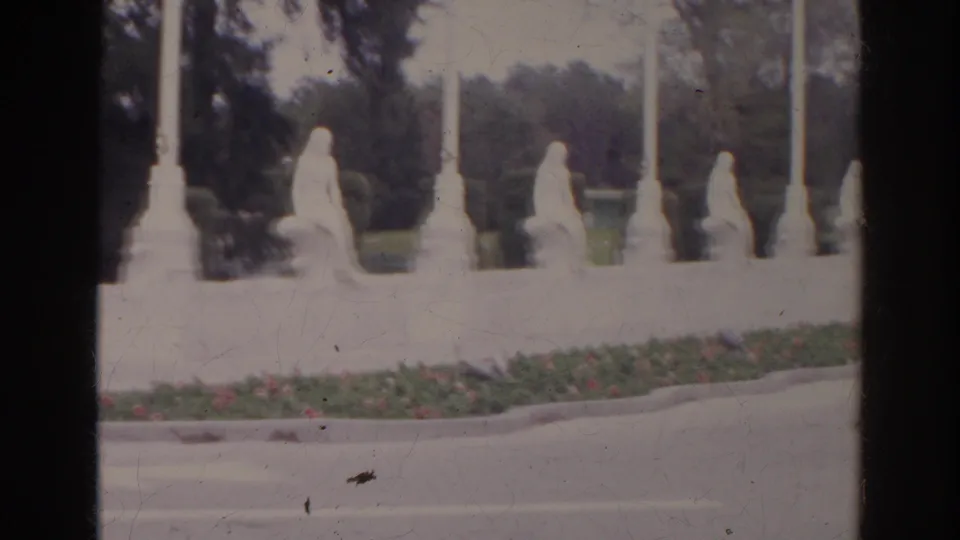1966 8mm frame of white seated statues along a landscaped median in the documented Norfolk, Virginia clip.