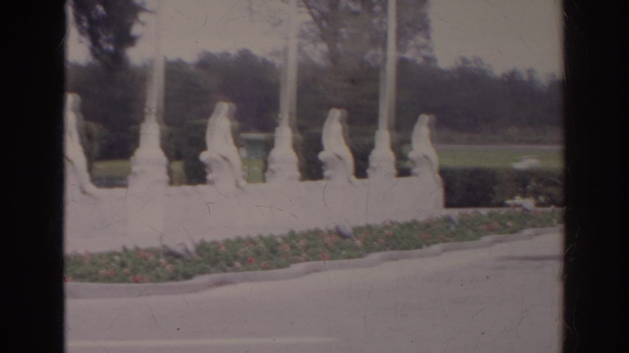 A second 1966 frame shows the statue row continuing past tall posts, with trees and roadway behind.