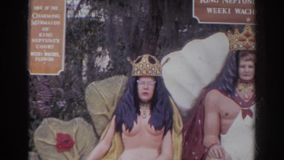 Two adults pose at the 1966 King Neptune's Court display, with a mermaid sign and shell-themed backdrop visible behind them.