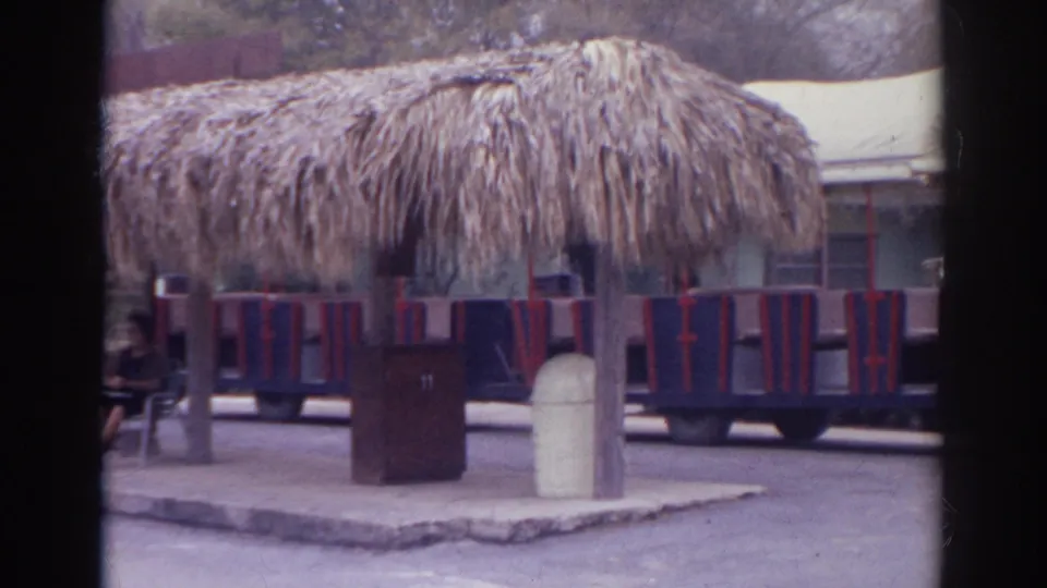 Small amusement-park train cars stand near a thatched shelter in Norfolk, Virginia, according to clip metadata.