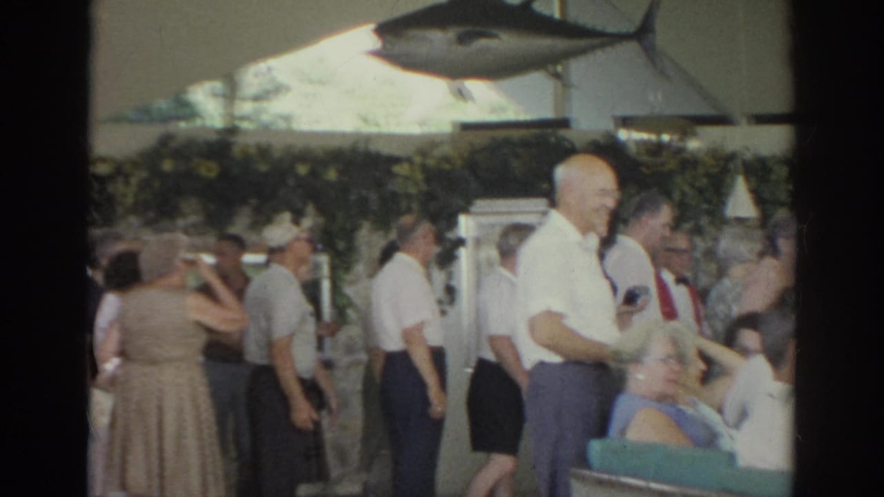 1966 Norfolk restaurant interior showing standing patrons, seated diners, and a large mounted tuna fish display on the wall.