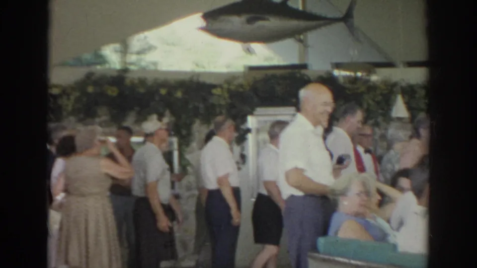 1966 Norfolk restaurant interior showing standing patrons, seated diners, and a large mounted tuna fish display on the wall.