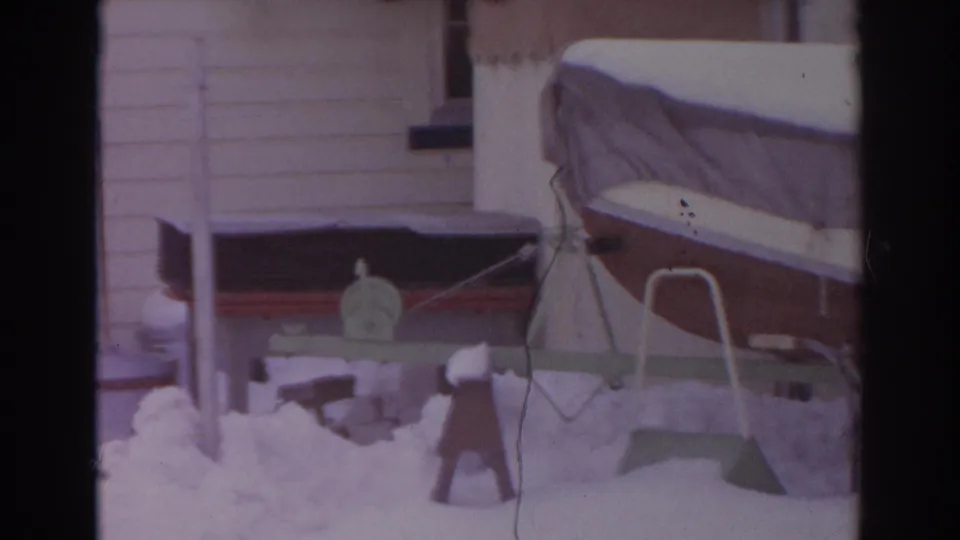 The final frame shows the snowy Norfolk backyard from 1966 with clothesline poles, house siding, and the edge of the covered boat.