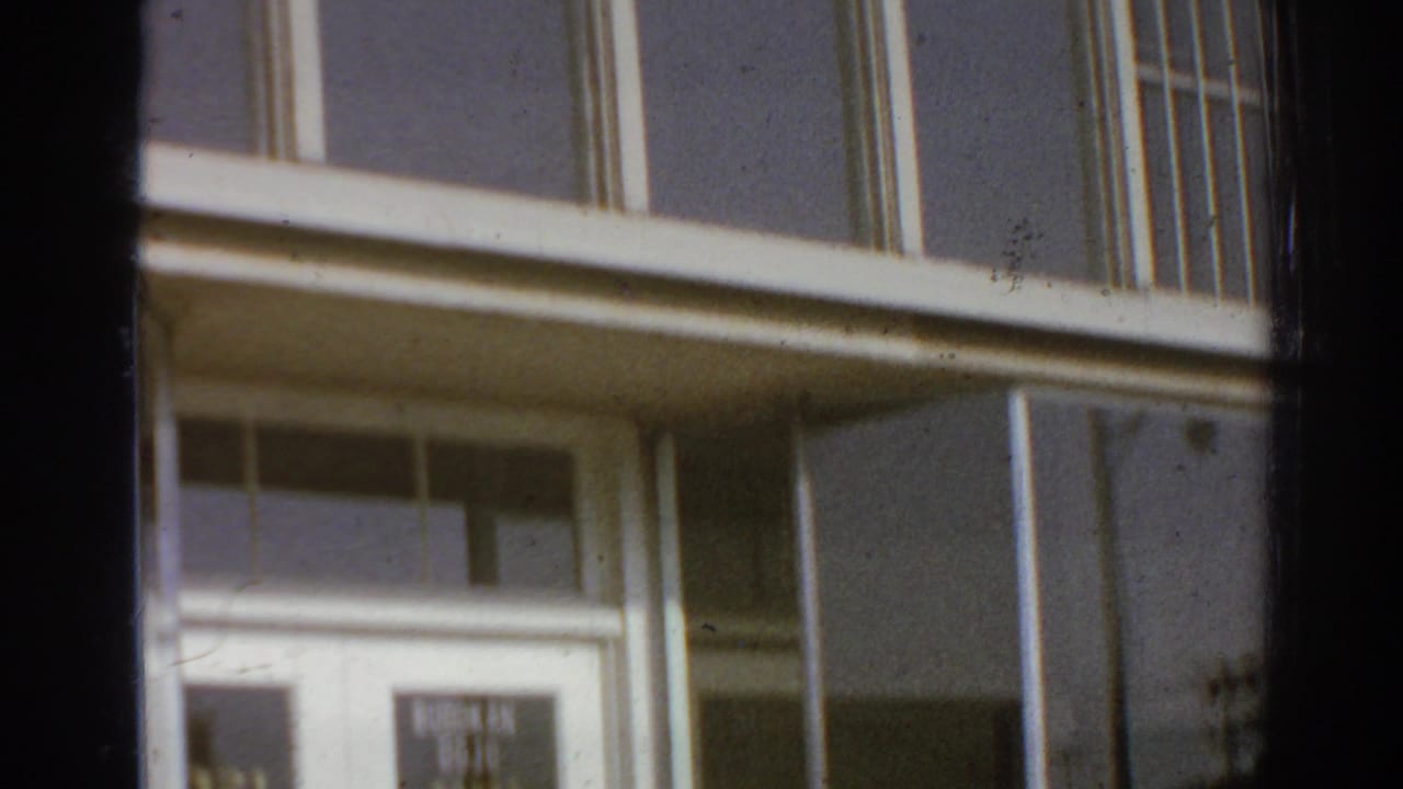 1966 San Gabriel, California exterior view of a white building with large window bays and a partially visible judo school sign.