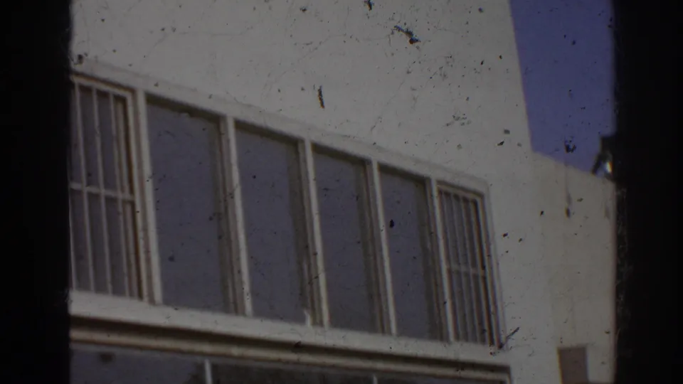 1966 San Gabriel exterior detail showing barred window bays on the white judo school building under blue sky.