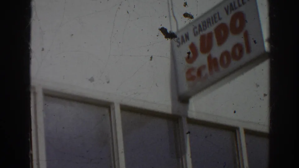 1966 San Gabriel frame revealing a projecting San Gabriel Valley Judo School sign above windows on the white exterior.