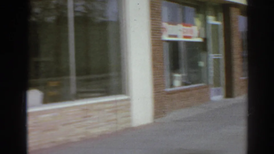 Brick-front commercial facade in San Gabriel with a window sign, glass door, and empty sidewalk beside the dojo entrance.