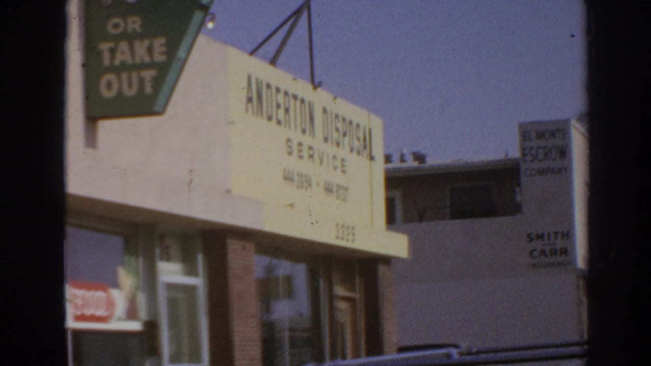 Streetfront with Anderton Disposal Service building and partial Mexican food take-out sign.