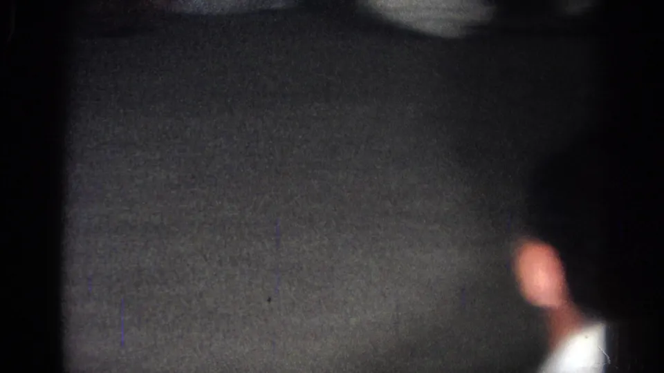Soft 8mm frame from the San Gabriel judo practice, with a blurred figure near the dark mat or floor.