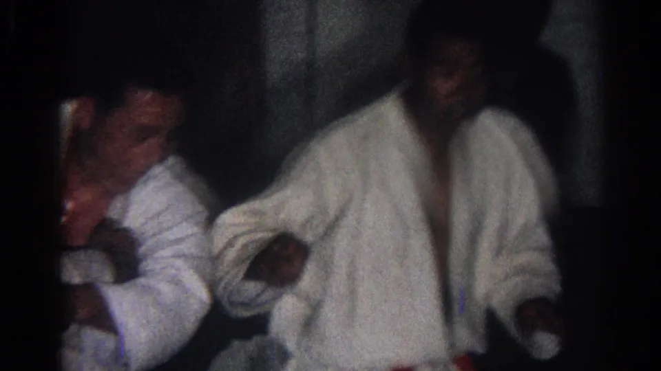1966 San Gabriel 8mm frame showing martial arts practitioners in white gi uniforms, including a partly visible adult face.