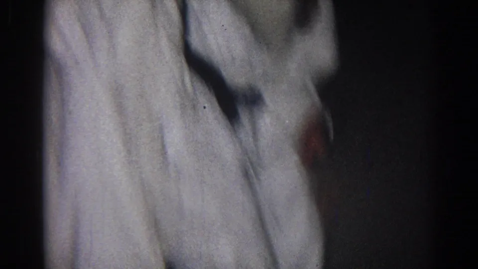 1966 San Gabriel home-movie frame showing two uniformed martial arts participants in close grappling contact.