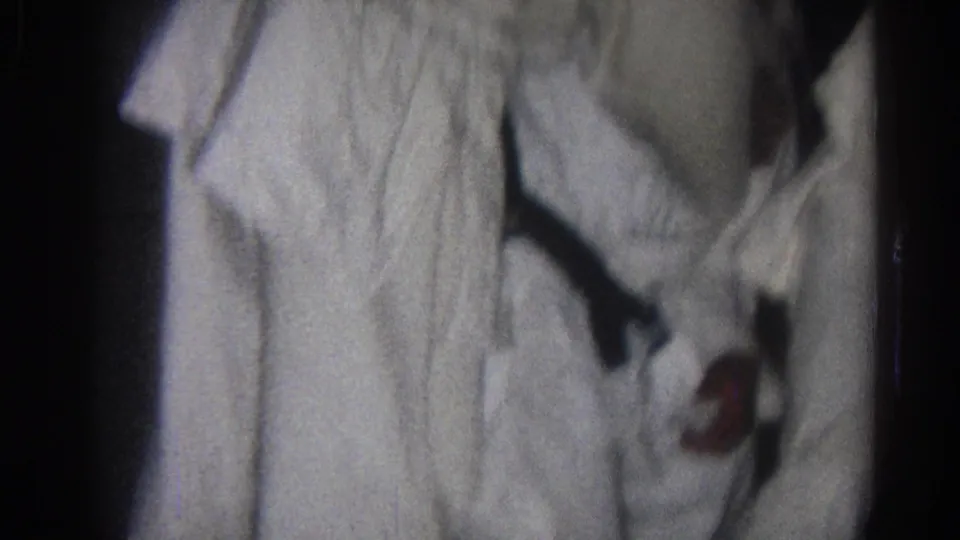 Home-movie frame from San Gabriel in 1966 showing a tight, low-light view of a martial arts grappling hold.