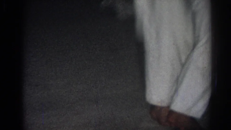 Low-framed 8mm view of a white gi and feet during indoor martial arts practice in the San Gabriel clip.