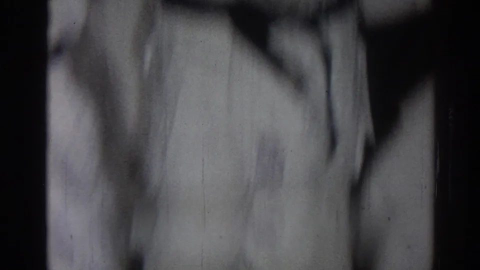 San Gabriel 1966 home-movie frame showing a blurred person in a white martial arts robe during practice.