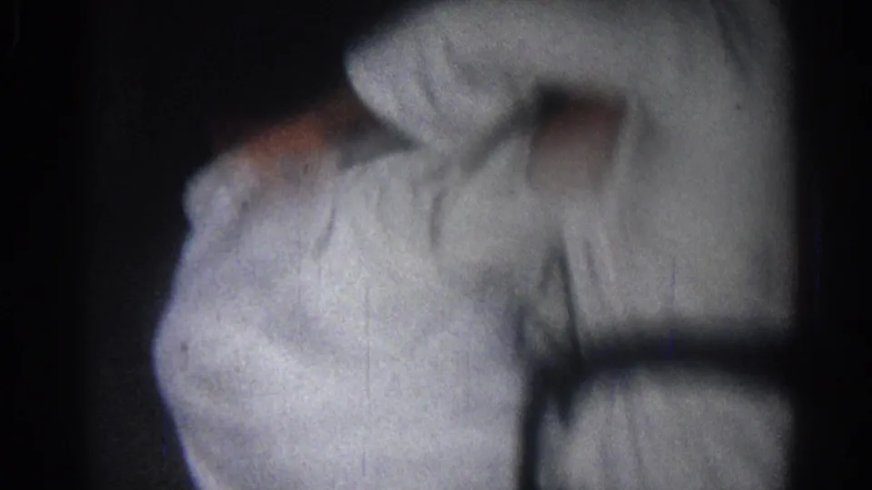 A close 1966 San Gabriel frame shows a karate practitioner in a white gi and dark belt during movement.