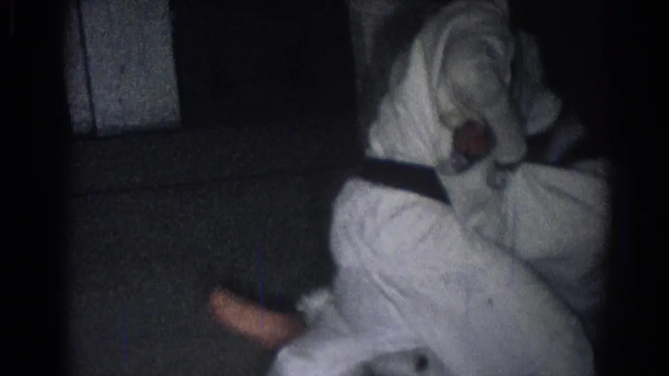 A 1966 home-movie frame shows a boy in a white gi on the floor as another student completes a grappling or throw practice movement indoors.