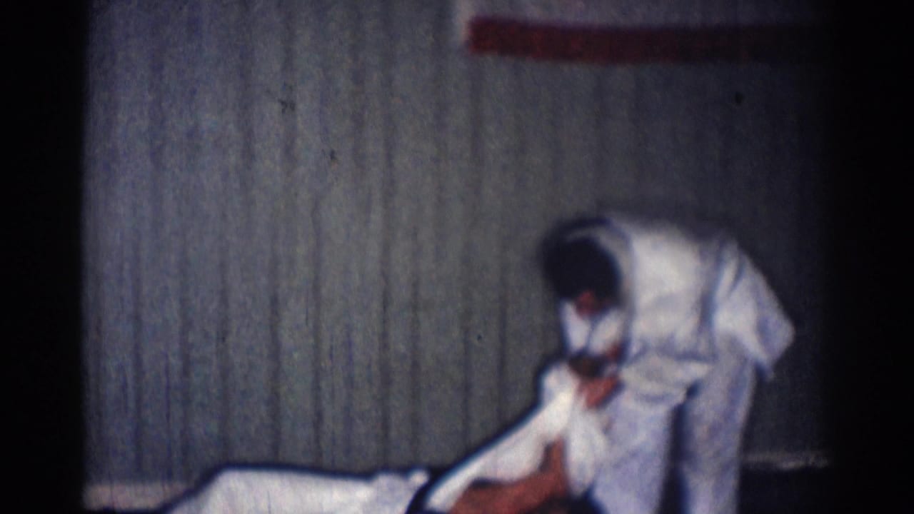 A martial arts partner appears down on the mat as the standing man bends over him during the 1966 dojo demonstration.
