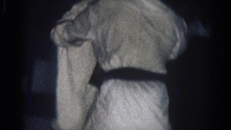 Close 8mm frame of a judo practitioner’s white gi and black belt during indoor grappling in the supplied 1966 San Gabriel clip.
