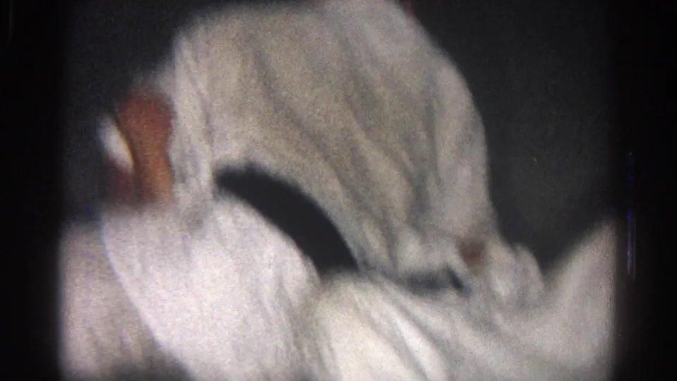 1966 San Gabriel dojo footage shows a white gi-clad participant bent forward as another person is partly obscured nearby.