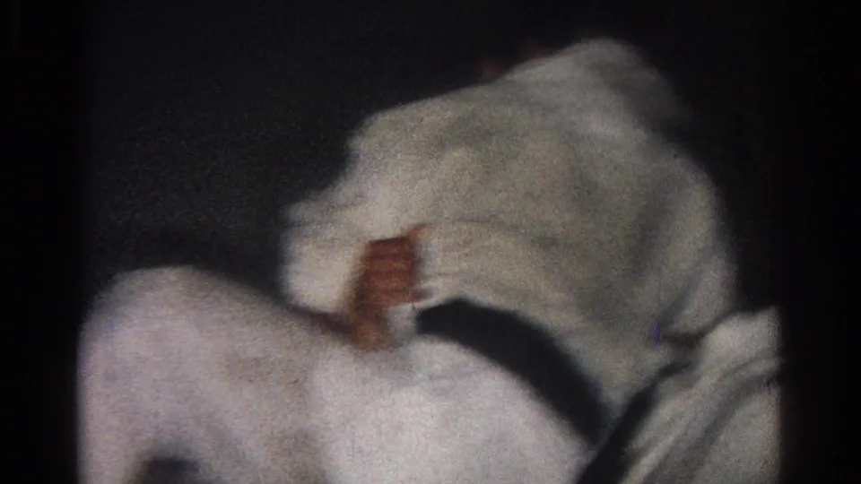 1966 San Gabriel 8mm frame showing two participants in white gi uniforms crouched or falling low during dojo sparring.