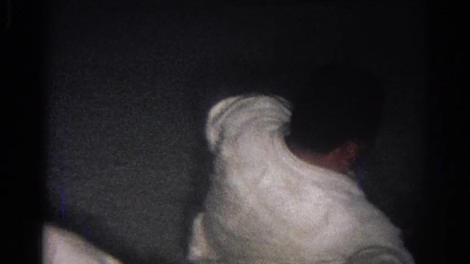1966 San Gabriel frame with a white-garbed judo athlete bent forward during close mat training in dim indoor light.