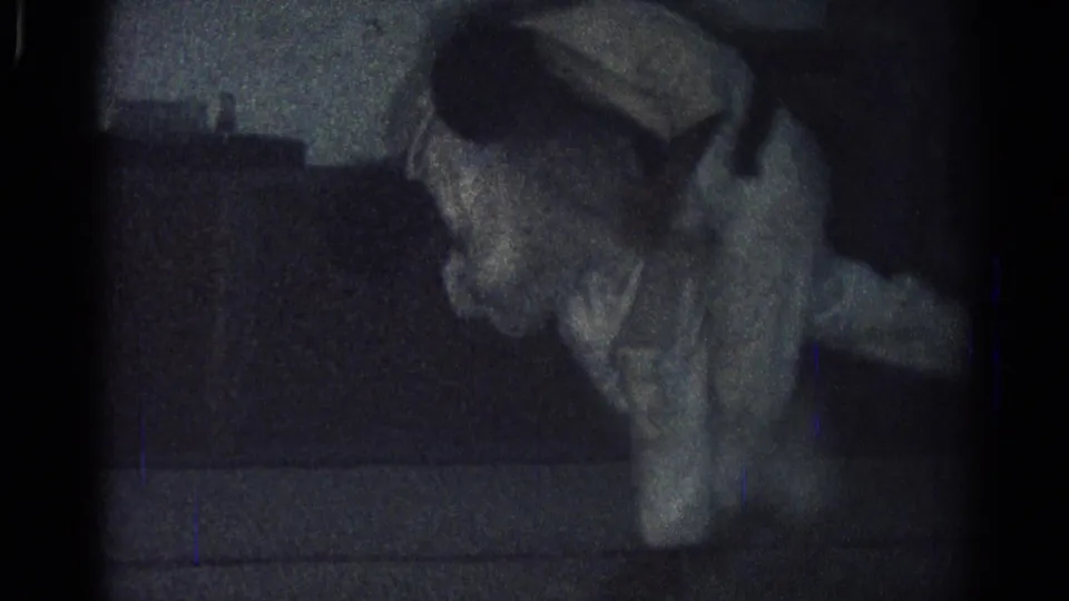 A gi-clad participant bends forward near the floor during the San Gabriel martial arts footage, with the room mostly in shadow.