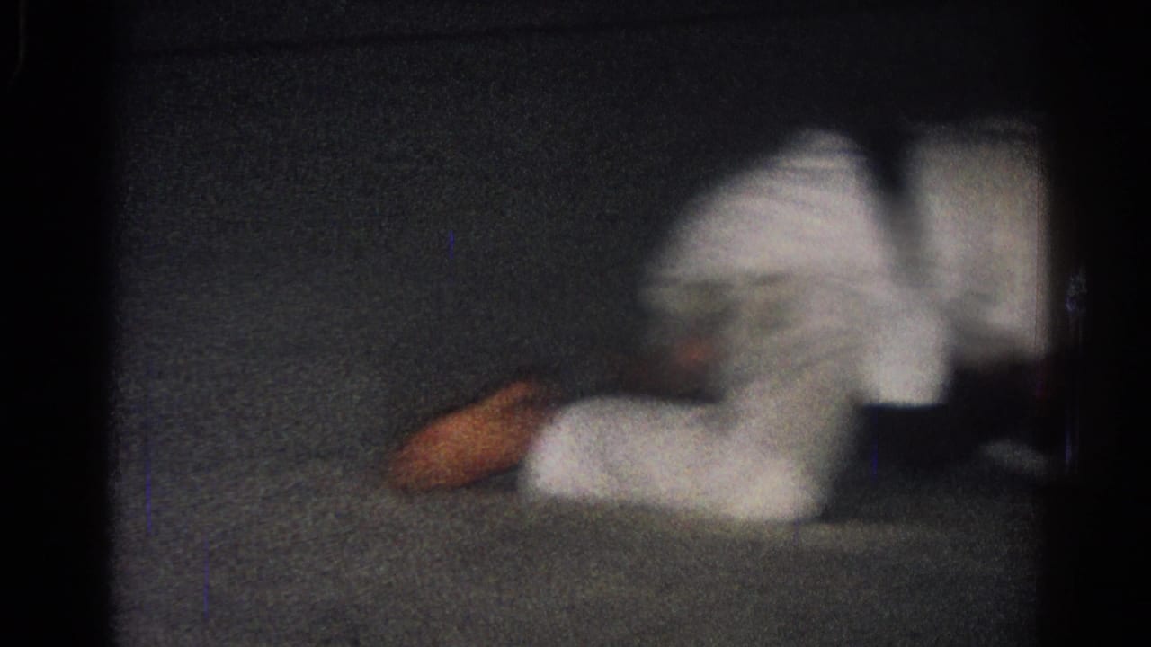 One uniformed competitor lies low on the mat during a grappling exchange.