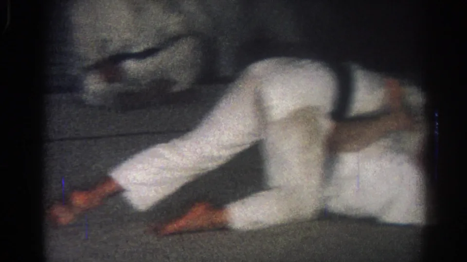 1966 San Gabriel frame showing a martial artist in a white uniform stretched sideways during ground grappling action.