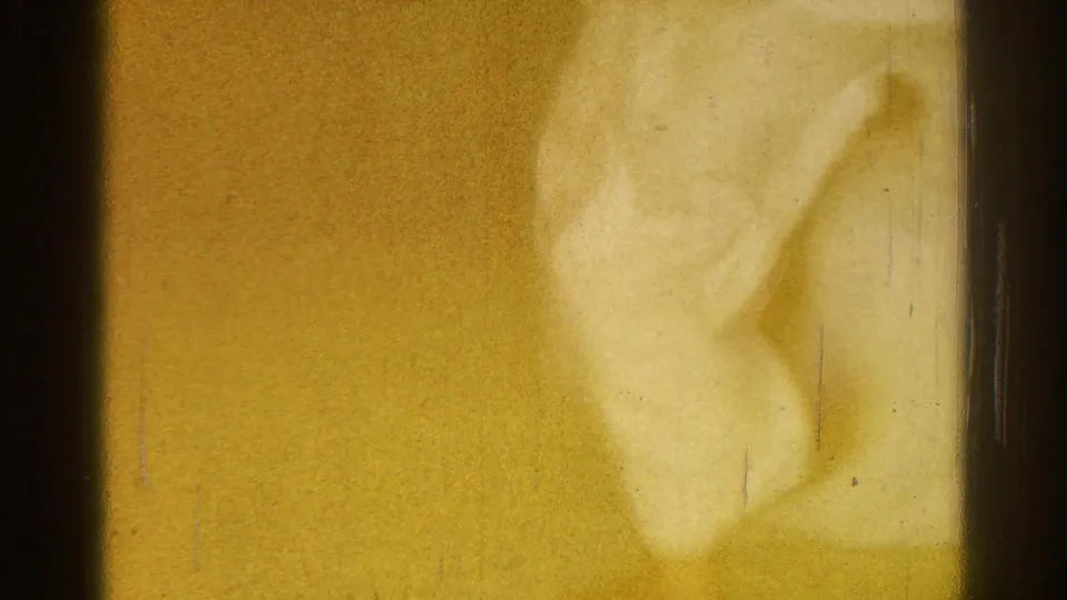 A damaged or overexposed 8mm frame from the 1966 San Gabriel judo clip, with a partial blurred white-gi figure visible at the edge.