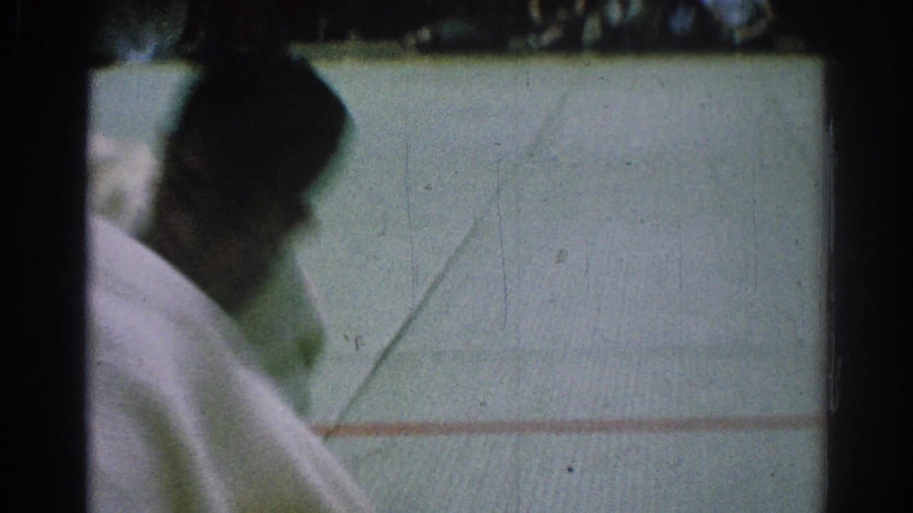 Blurred karate competitor in a white gi near the edge of a mat.