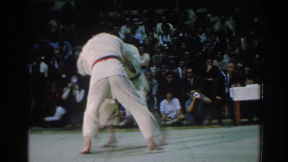 The final frame shows a blurred throw attempt as one competitor drives forward on the mat before the seated crowd.