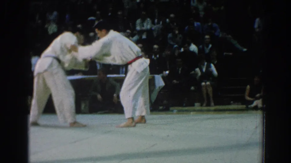 San Gabriel, California 1966 footage shows two male karate competitors in white gi engaging on a mat before spectators.