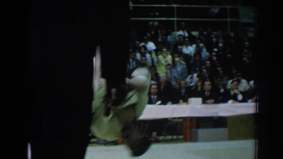 A competitor appears mid-throw or falling at the edge of the mat during the 1966 San Gabriel martial arts match.
