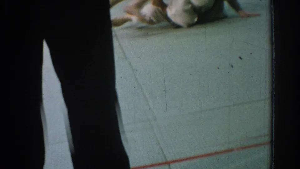 At the end of the 1966 San Gabriel exchange, a competitor in a white gi is down on the gym mat before the audience.