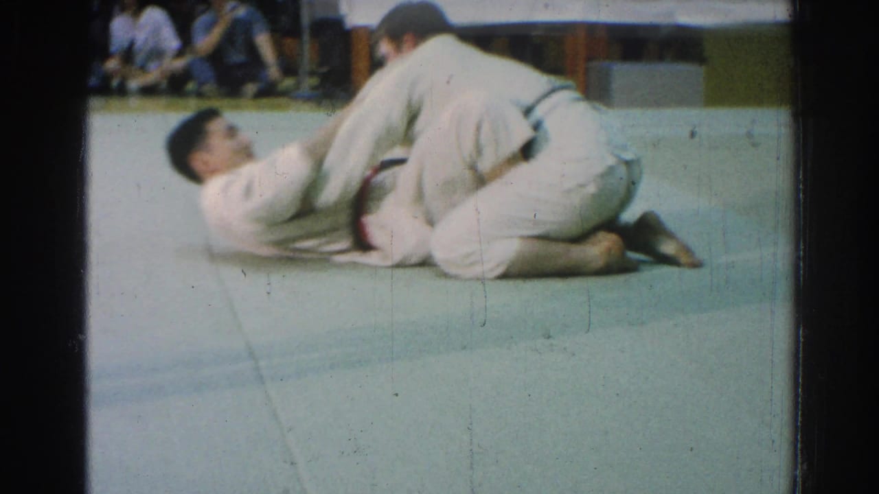 A karate match in the supplied San Gabriel 1966 clip shows one competitor kneeling while the other is down on the mat.