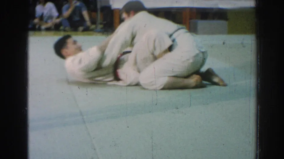 A karate match in the supplied San Gabriel 1966 clip shows one competitor kneeling while the other is down on the mat.
