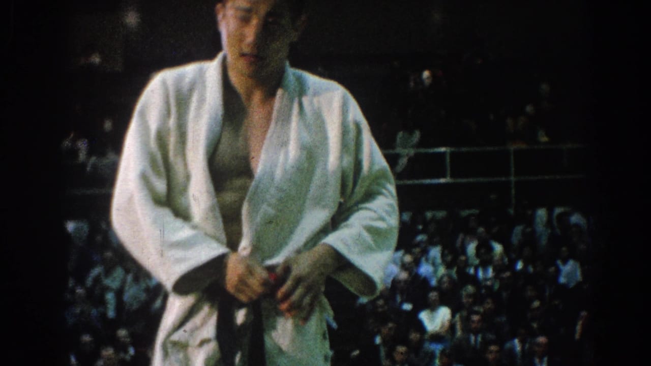 Close view of a karate competitor adjusting his belt in front of spectators.