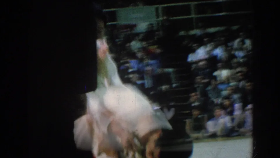 The final 1966 San Gabriel judo frame catches a blurred fall or roll on the mat, emphasizing the speed of the throw before seated spectators.
